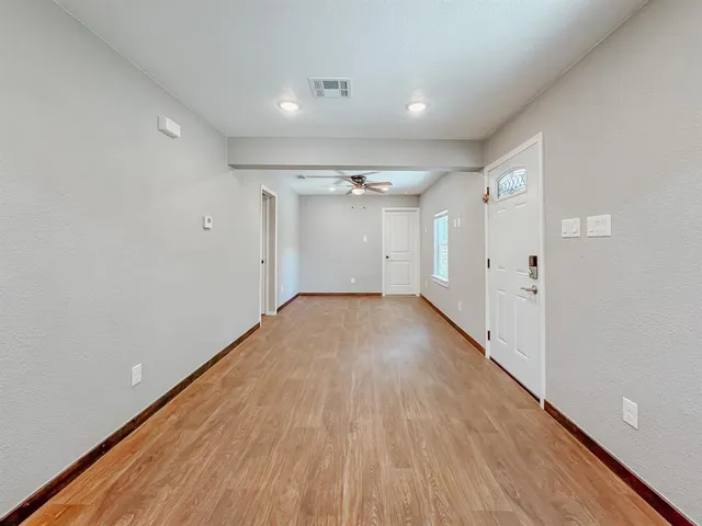 a view of empty room with wooden floor