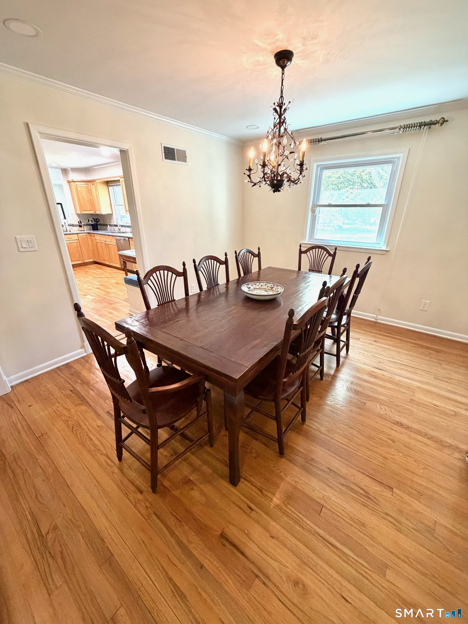 511 Roxbury Road Stamford, CT 06902 - Photo 6 of 19 a dining room with furniture a chandelier and wooden floor