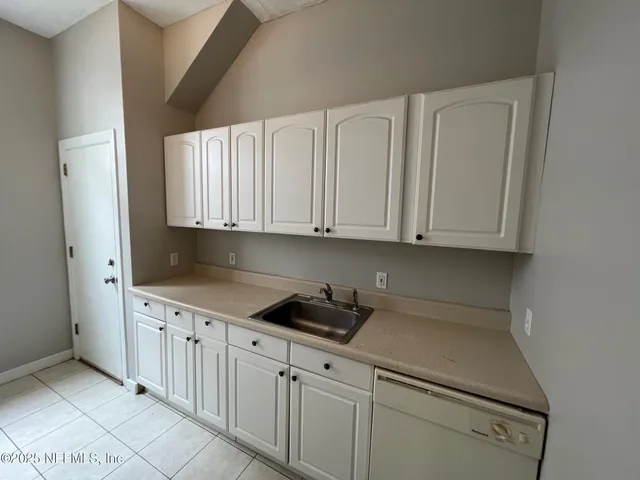 a kitchen with granite countertop white cabinets and sink