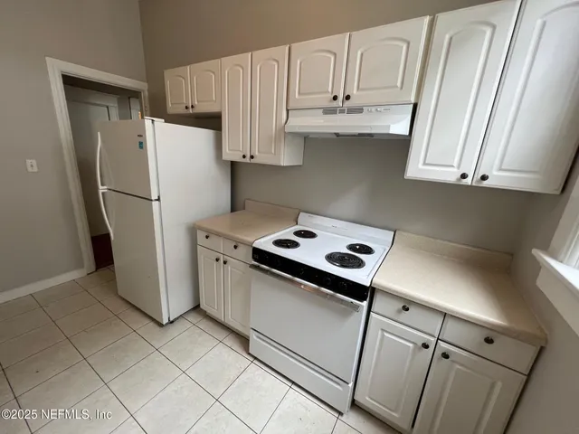 a kitchen with stainless steel appliances white cabinets and a refrigerator