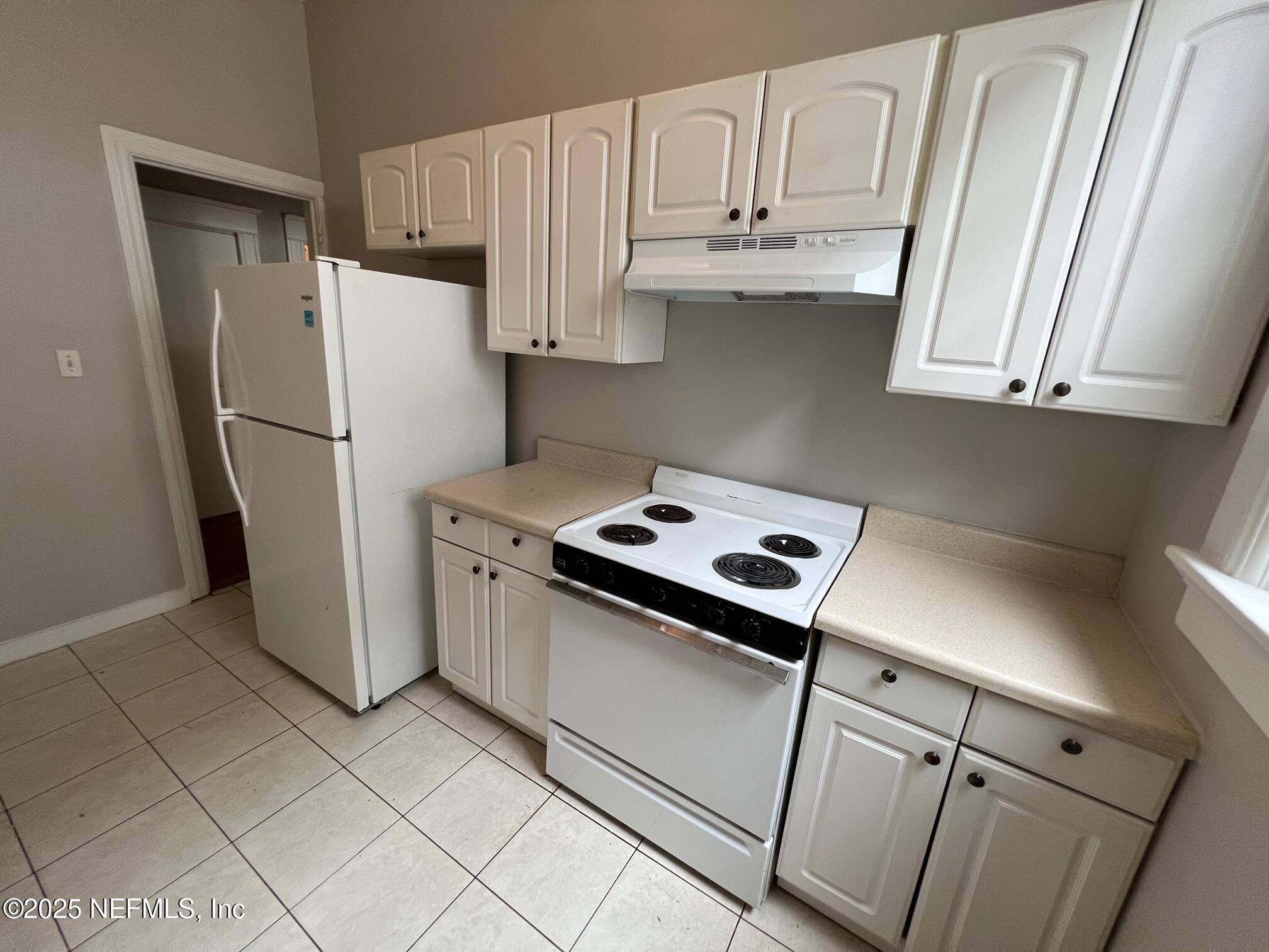 2627 Post Street, Unit 2 Jacksonville, FL 32204 - Photo 6 of 13 a kitchen with stainless steel appliances white cabinets and a refrigerator