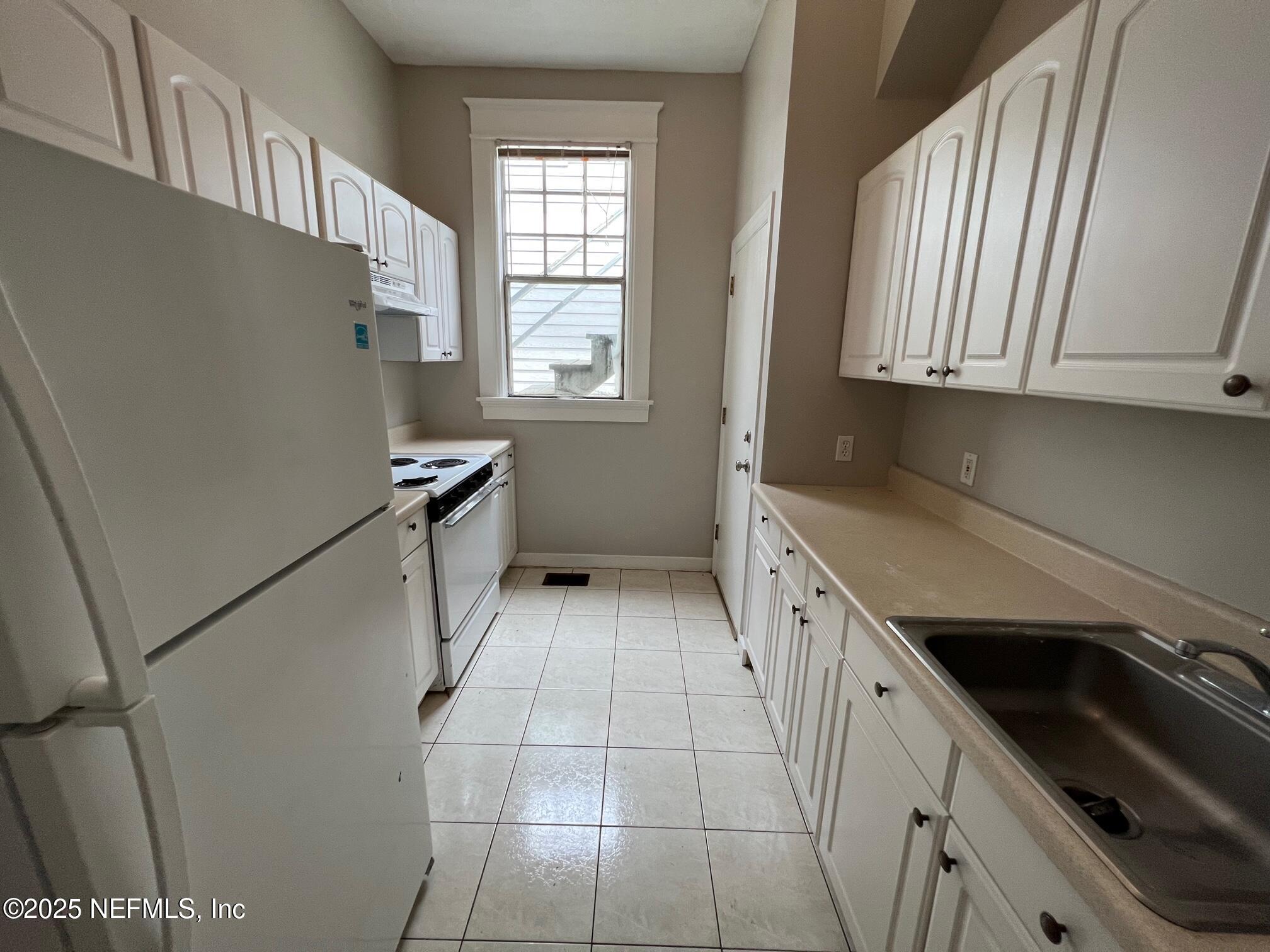 2627 Post Street, Unit 2 Jacksonville, FL 32204 - Photo 8 of 13 a kitchen with granite countertop white cabinets and white appliances