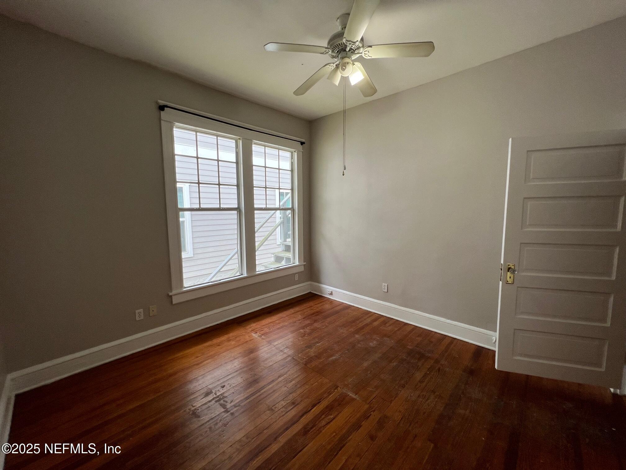 2627 Post Street, Unit 2 Jacksonville, FL 32204 - Photo 9 of 13 an empty room with wooden floor fan and windows