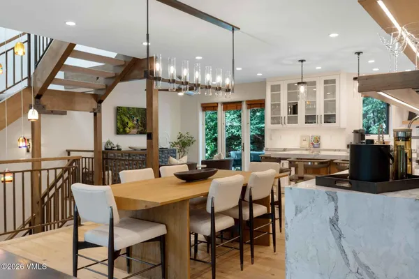 a dining room with furniture a chandelier and wooden floor