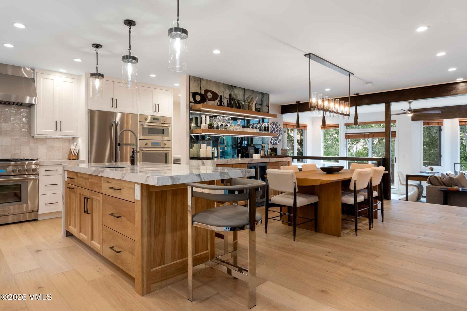 1592 Golf Terrace, Unit 55 Vail, CO 81657 - Photo 14 of 34 a kitchen with stainless steel appliances kitchen island granite countertop a table chairs and a view of living room
