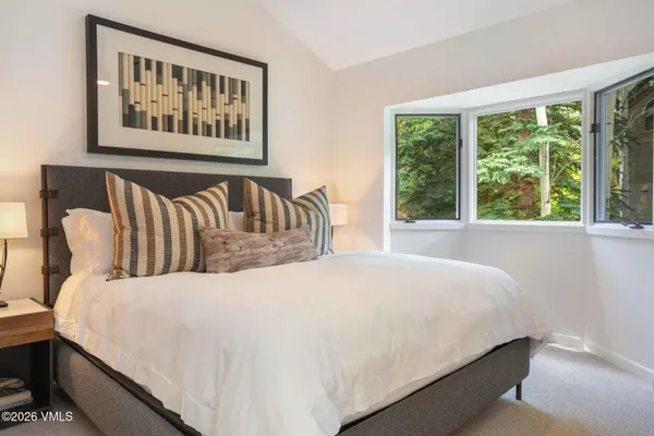 a large bed sitting in a bedroom next to a window