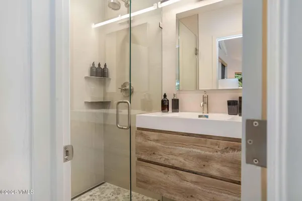 a bathroom with a bathtub sink vanity and mirror