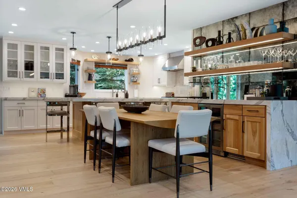 a kitchen with a dining table chairs sink and cabinets