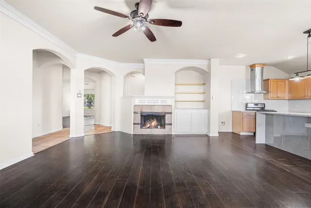a view of a room with wooden floor and kitchen view
