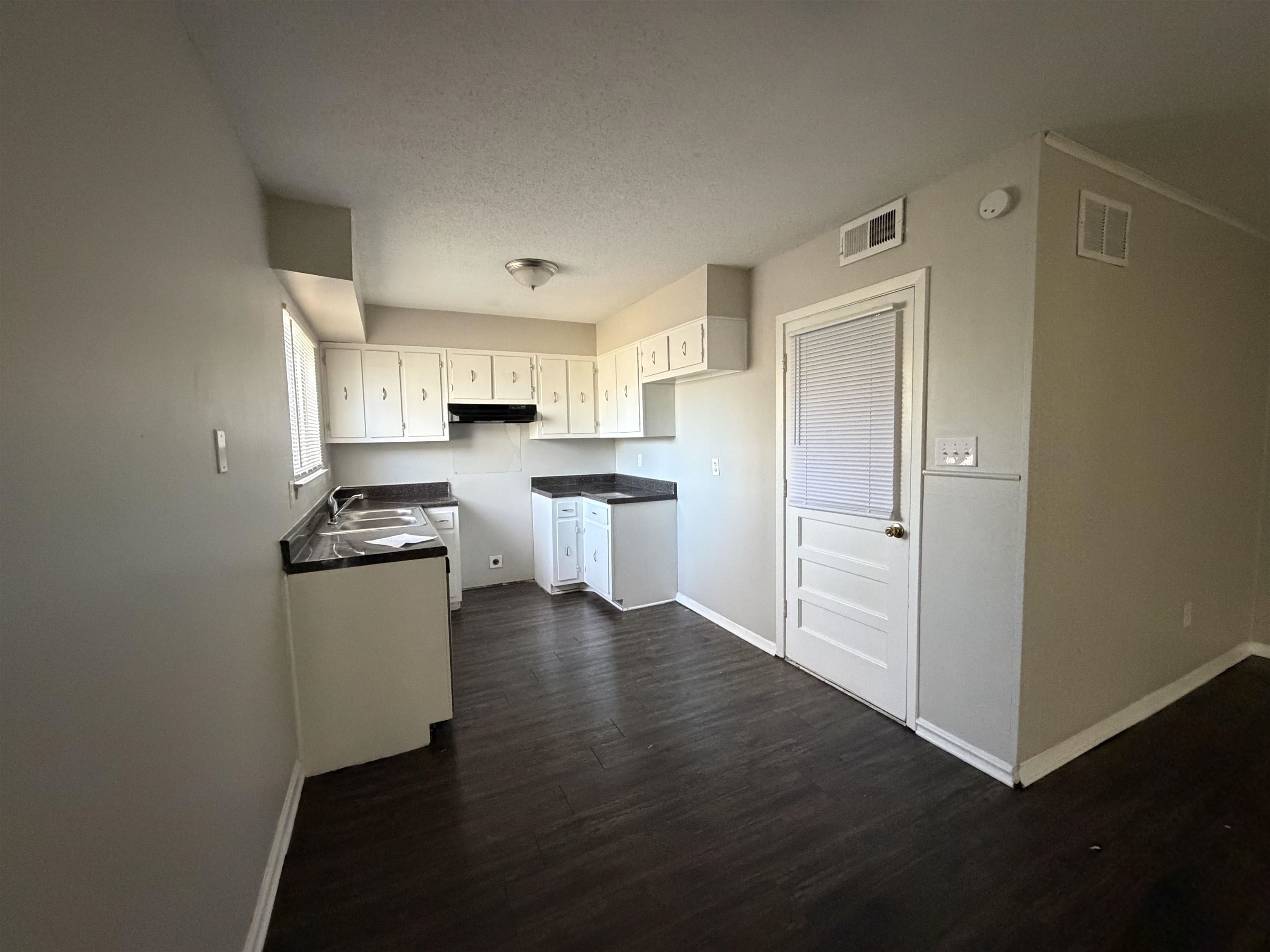 6302 Leamont Drive Millington, TN 38053 - Photo 5 of 11 Kitchen with white cabinetry, dark countertops, a textured ceiling, dark wood-style floors, and under cabinet range hood
