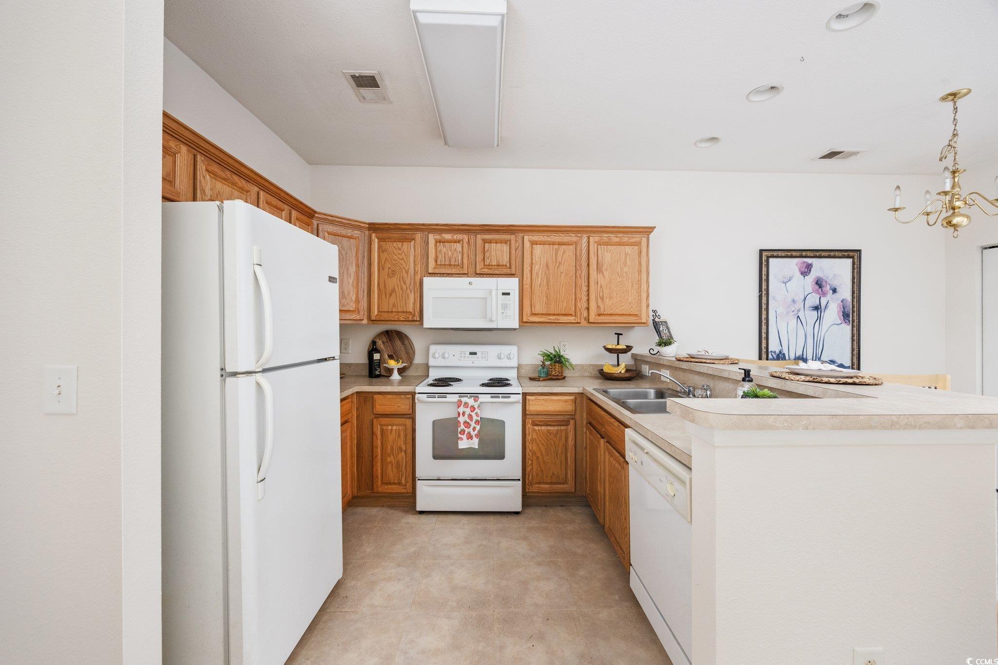 155 Chenoa Drive, Unit E Murrells Inlet, SC 29576 - Photo 11 of 34 Kitchen featuring dishwasher, light colored carpet, pendant lighting, light countertops, and a chandelier