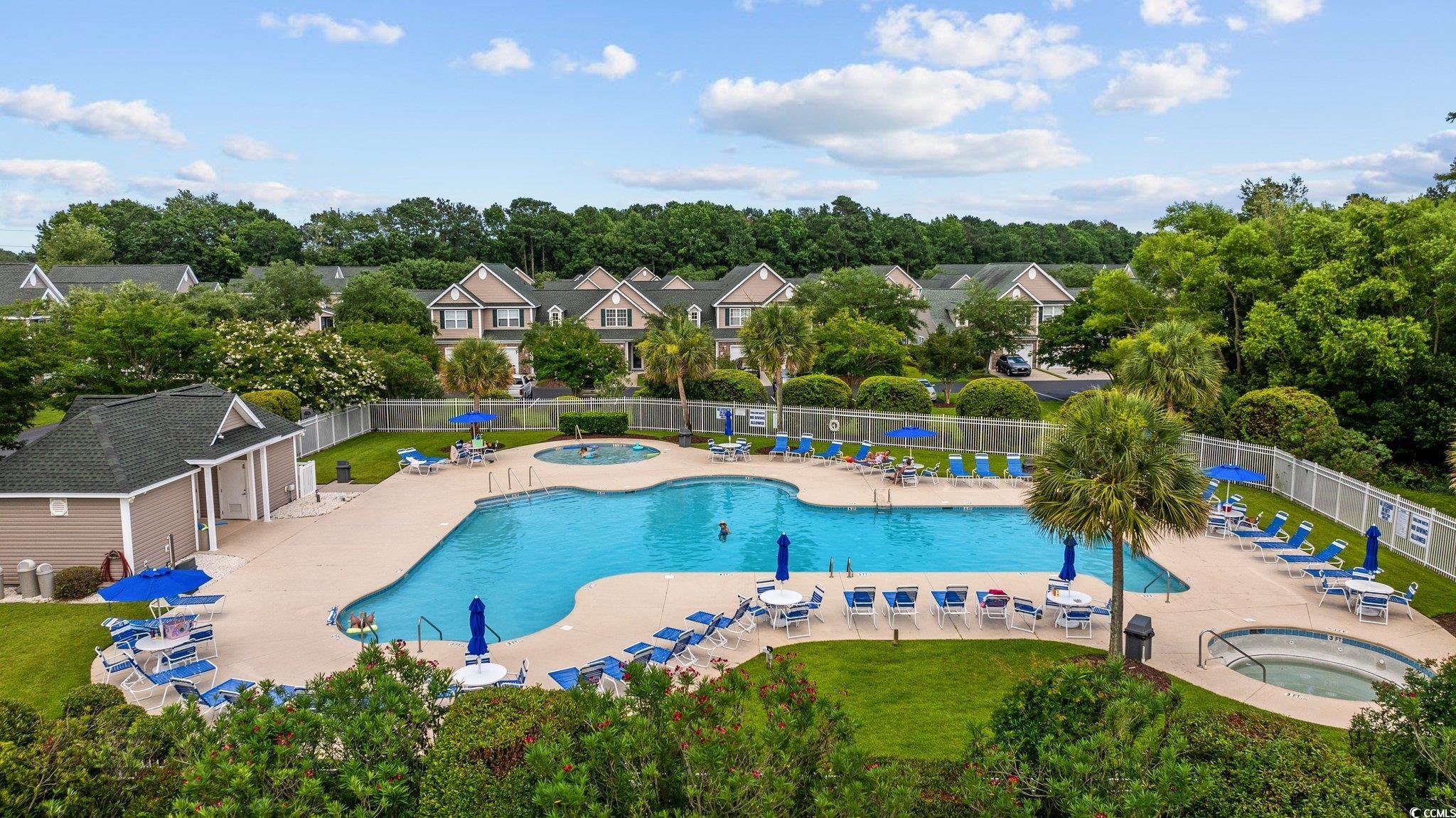 155 Chenoa Drive, Unit E Murrells Inlet, SC 29576 - Photo 2 of 34 Community pool with a community hot tub, a patio, and view of wooded area