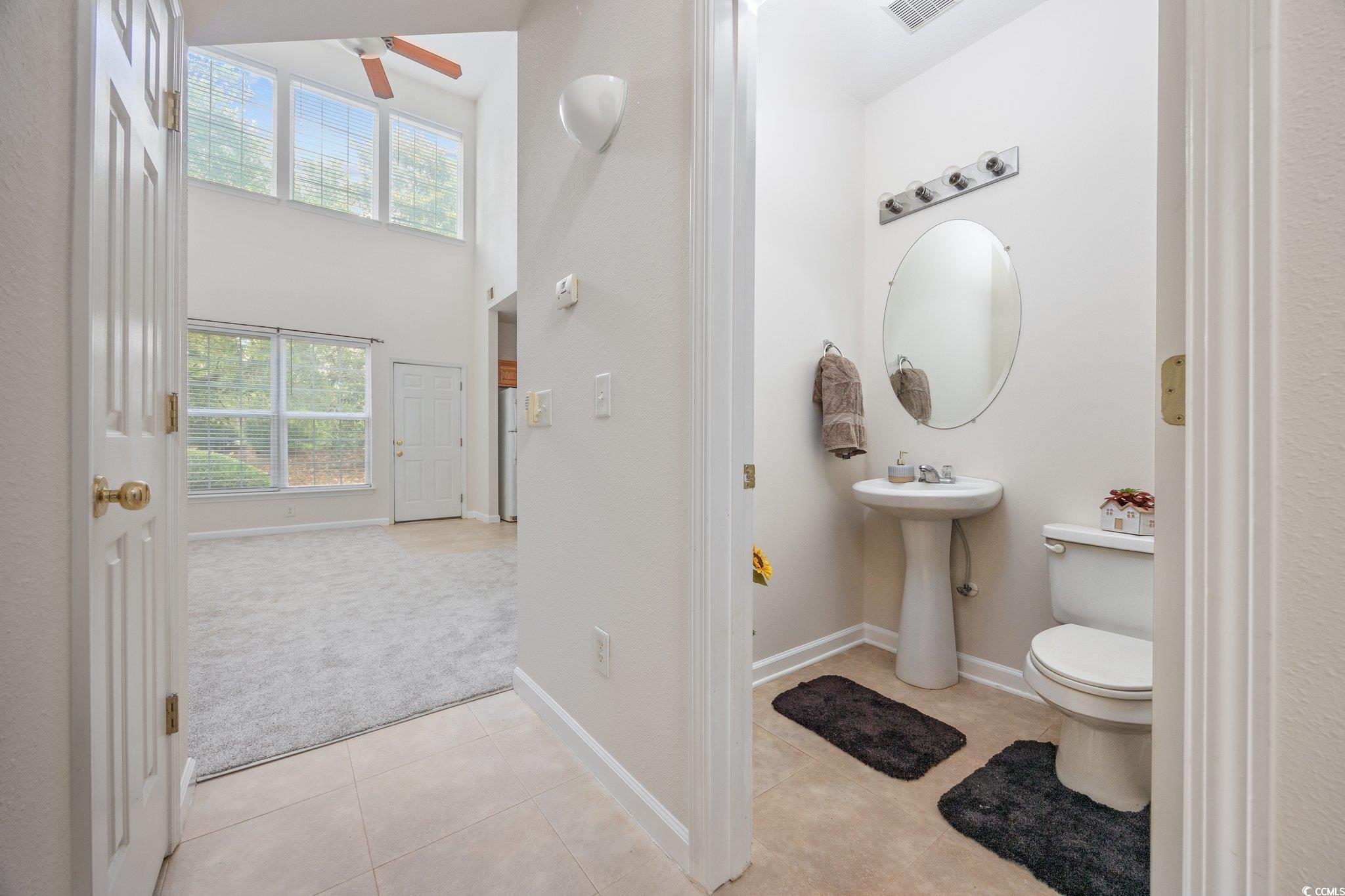 155 Chenoa Drive, Unit E Murrells Inlet, SC 29576 - Photo 21 of 34 Unfurnished bedroom with carpet, a spacious closet, connected bathroom, a ceiling fan, and a closet