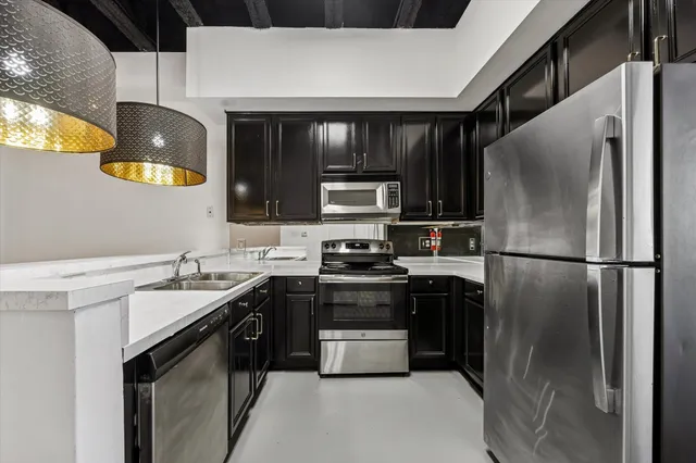 a kitchen with stainless steel appliances granite countertop a stove a refrigerator and a sink