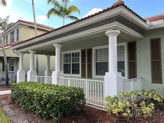 a front view of a house with a garden and trees