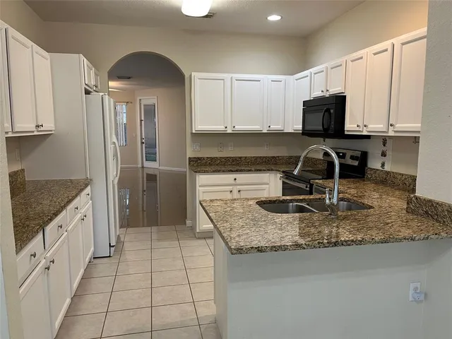 a kitchen with stainless steel appliances granite countertop a sink stove and microwave