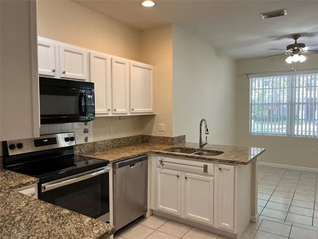 a kitchen with stainless steel appliances granite countertop a sink and cabinets