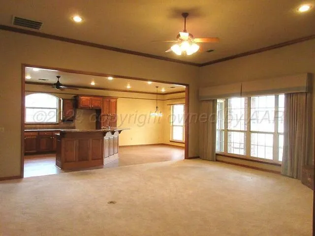 a view of an empty room with window and cabinet
