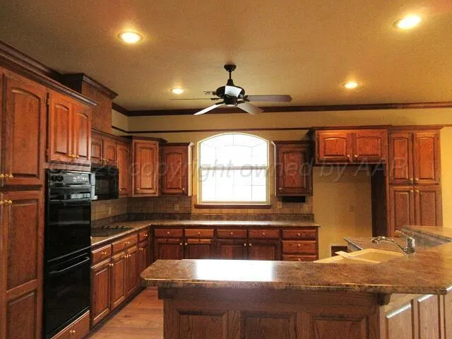 a kitchen with stainless steel appliances granite countertop a sink a stove and a refrigerator