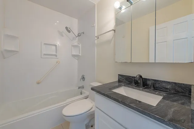 a bathroom with a granite countertop sink toilet and shower