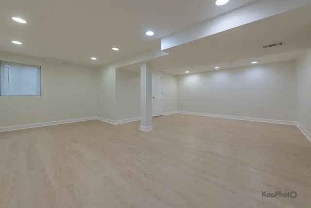 an empty room with a ceiling fan and window