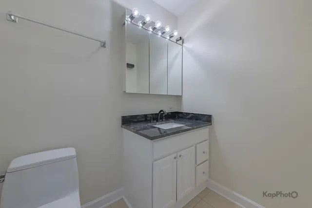 a bathroom with a granite countertop sink and a mirror