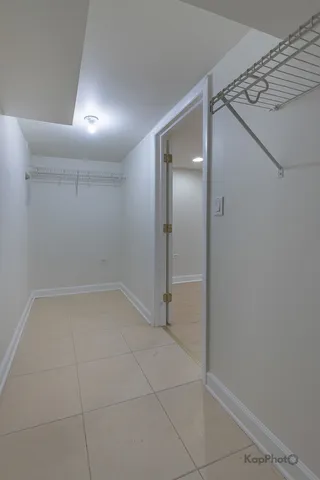 a view of a refrigerator in kitchen and an empty room