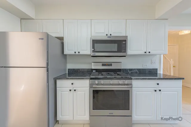 a kitchen with cabinets stainless steel appliances and a counter space