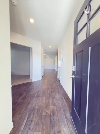 a view of a big room with wooden floor and a kitchen