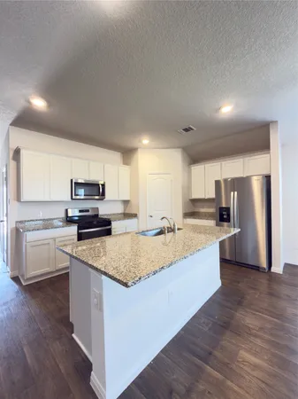 a large kitchen with a center island and stainless steel appliances