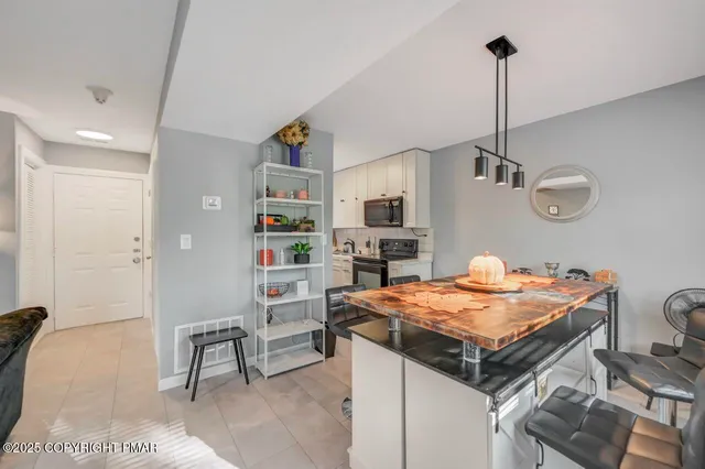 a room with kitchen island a wooden floor and refrigerator