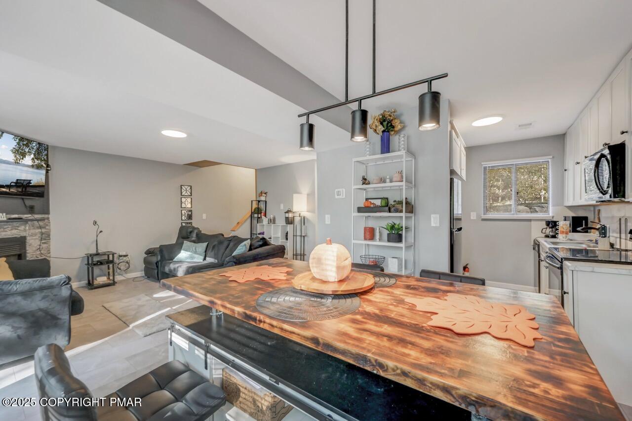 3305 Windemere Drive Bushkill, PA 18324 - Photo 16 of 56 a room with kitchen island a wooden floor and refrigerator