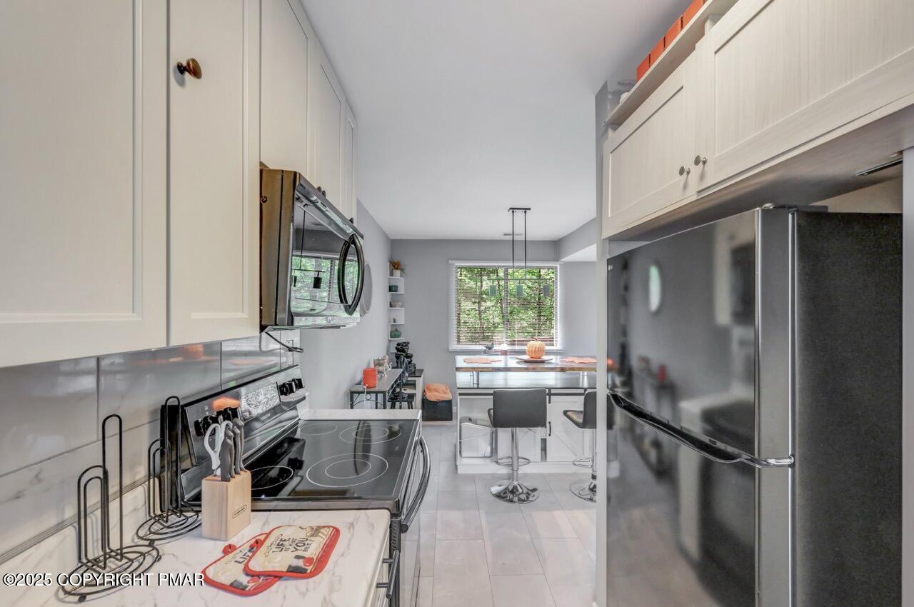 3305 Windemere Drive Bushkill, PA 18324 - Photo 19 of 56 a kitchen with stainless steel appliances granite countertop a refrigerator sink and wooden floor