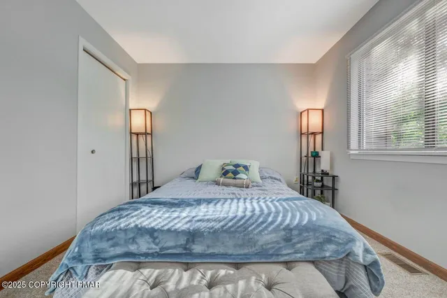 a bedroom with a bed and a dresser next to a window