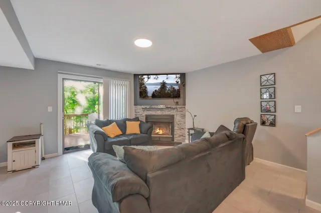 a living room with furniture a fireplace and a flat screen tv
