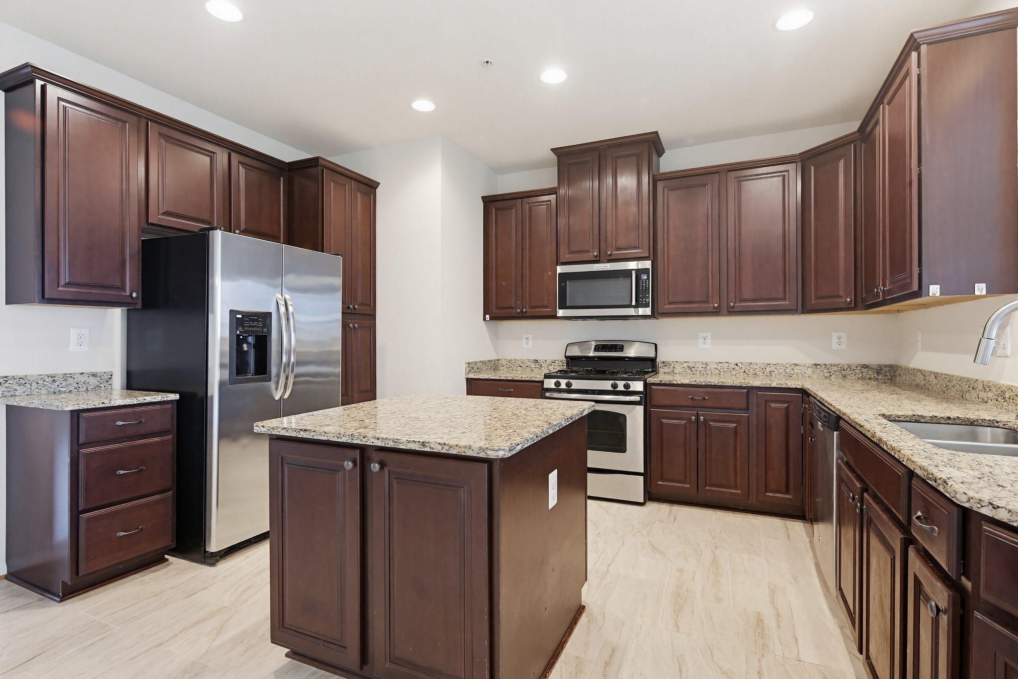 3819 Cullingworth Road Burtonsville, MD 20866 - Photo 11 of 50 a kitchen with stainless steel appliances granite countertop wooden cabinets a stove top oven a sink and dishwasher