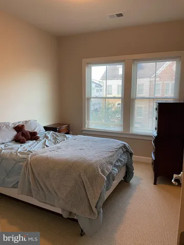 a bedroom with a bed tv and a window