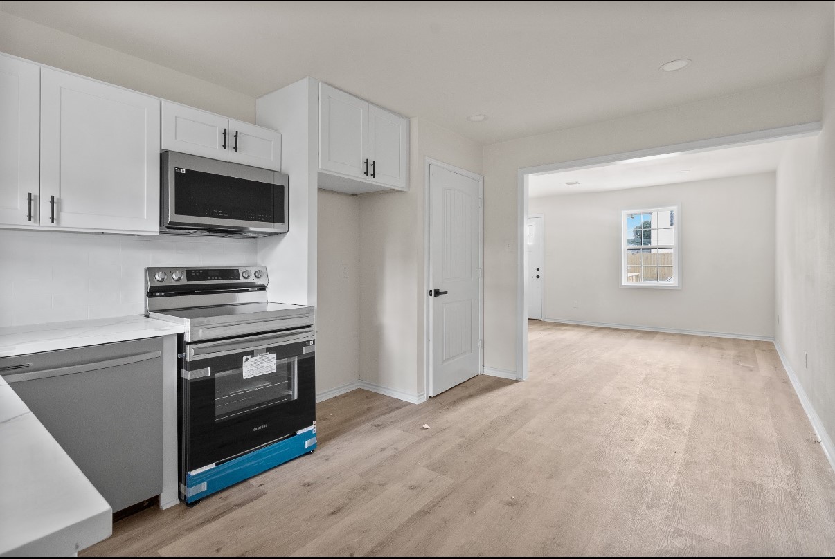 5031 Mallow Street Houston, TX 77033 - Photo 4 of 11 a kitchen with stainless steel appliances a stove microwave and sink
