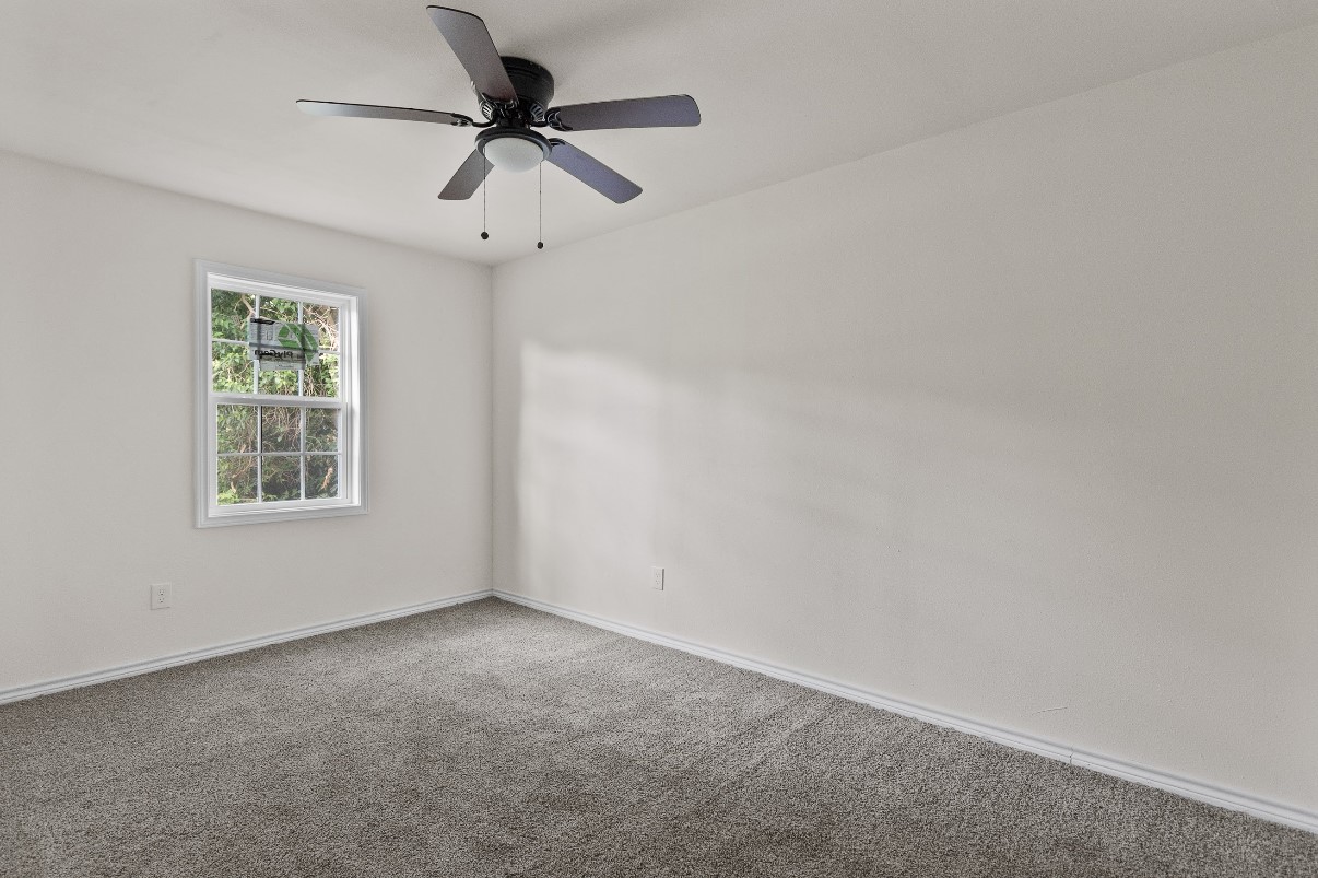 5031 Mallow Street Houston, TX 77033 - Photo 7 of 11 an empty room with a window and a fan