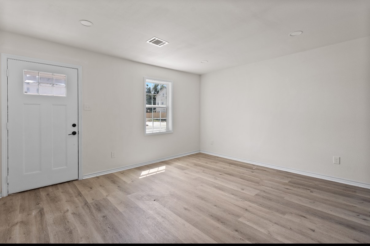 5031 Mallow Street Houston, TX 77033 - Photo 8 of 11 an empty room with wooden floor and windows