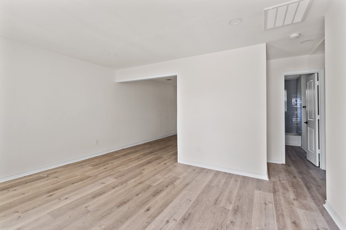 5031 Mallow Street Houston, TX 77033 - Photo 9 of 11 a view of an empty room with wooden floor