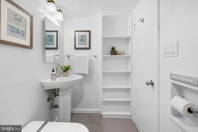 a bathroom with a sink toilet and a mirror
