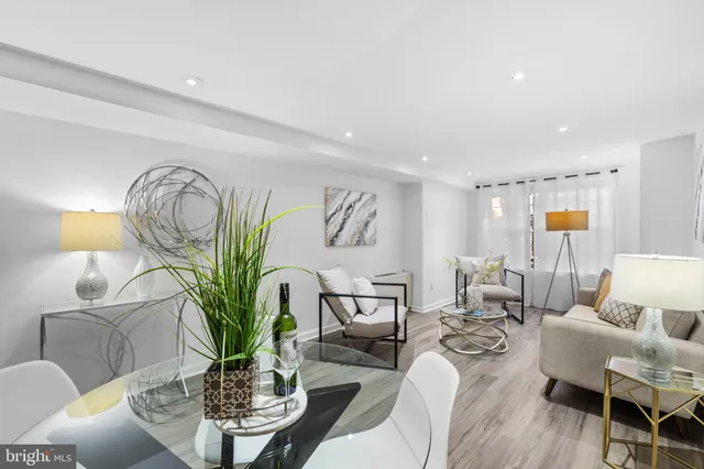 a living room with furniture a chandelier and a potted plant