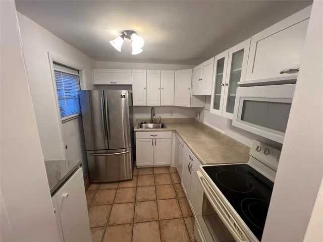 a kitchen with a stove a refrigerator and cabinets