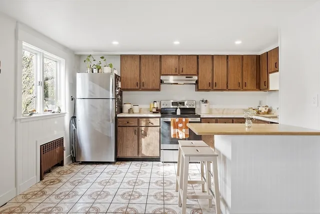 a kitchen with a refrigerator a counter top space and cabinets