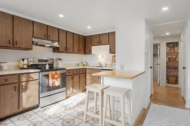 a kitchen with kitchen island granite countertop wooden cabinets and white appliances