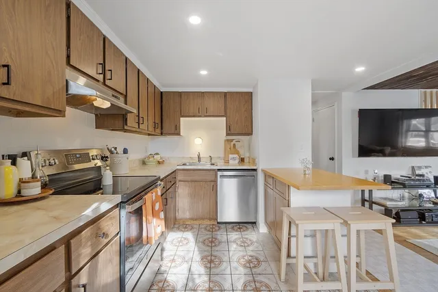 a kitchen with stainless steel appliances granite countertop a sink and a stove