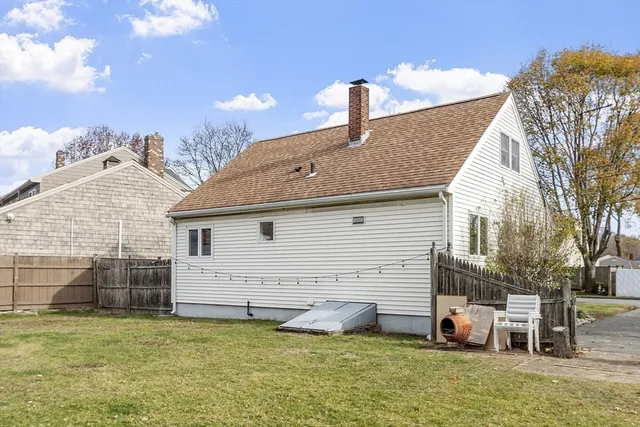 a view of a house with backyard and a tree