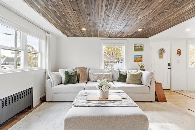 a living room with furniture a chandelier and a dining table with wooden floor