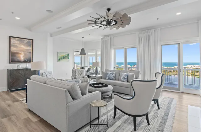 a living room with furniture potted plant and open kitchen view